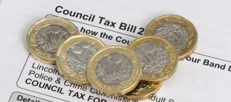 Council Tax Bill with pound coins on top of it