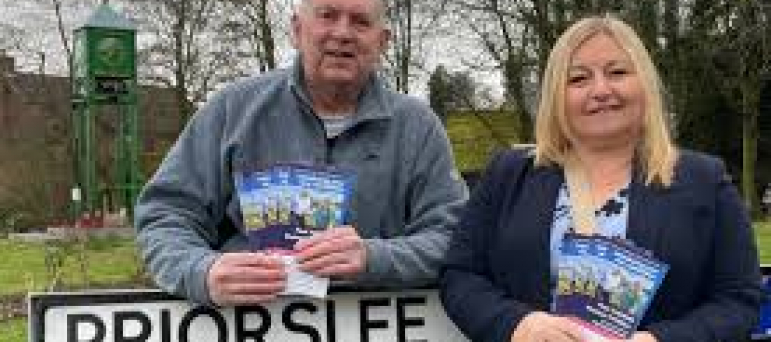 Cllrs Paul Thomas and Rachael Tyrell leaning on a Priorslee road sign
