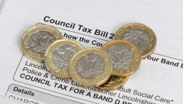 Council Tax Bill with pound coins on top of it