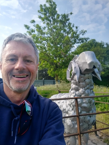 Cllr Tim Nelson standing next to a metal sheep